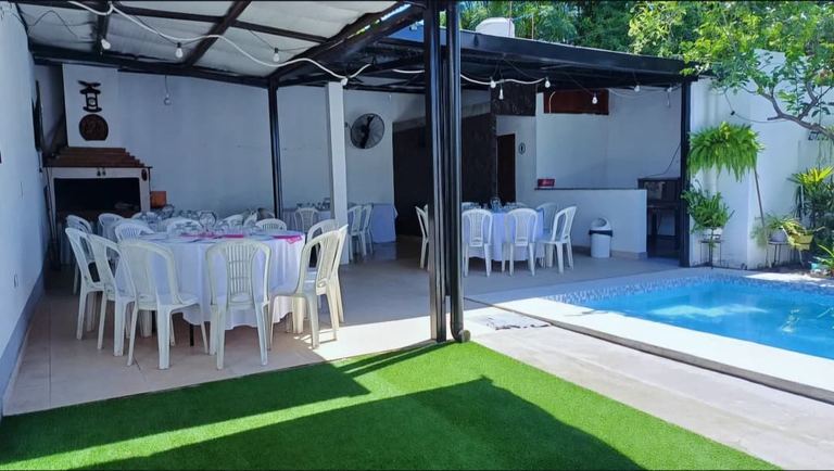 Césped sintético junto al patio techado con asador
