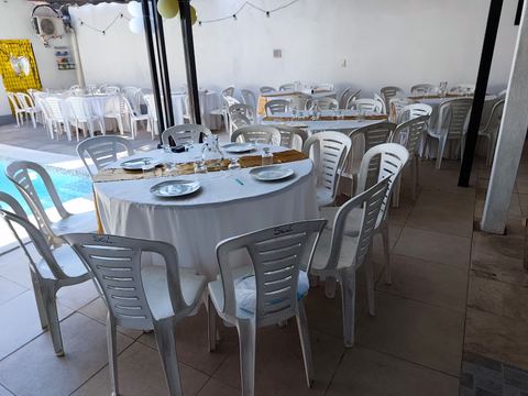 Vista amplia del patio techado y la pileta con mesas montadas para un evento